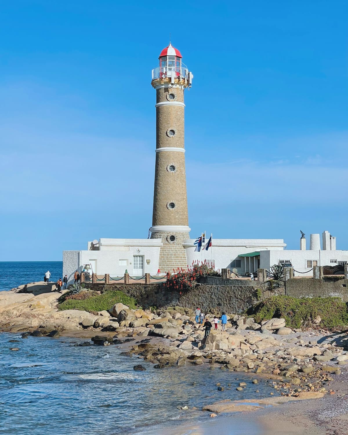 The José Ignacio lighthouse above the rocks at the water's edge