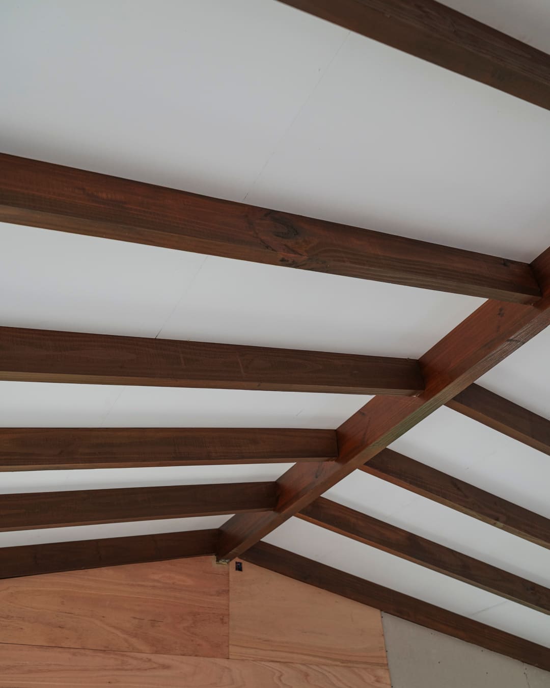 Dark roof beams against the white ceiling, seen from below.