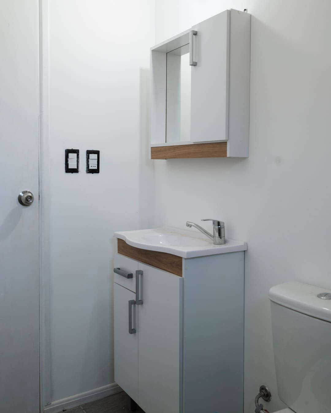 Bathroom with a white vanity unit and mirror cabinet.
